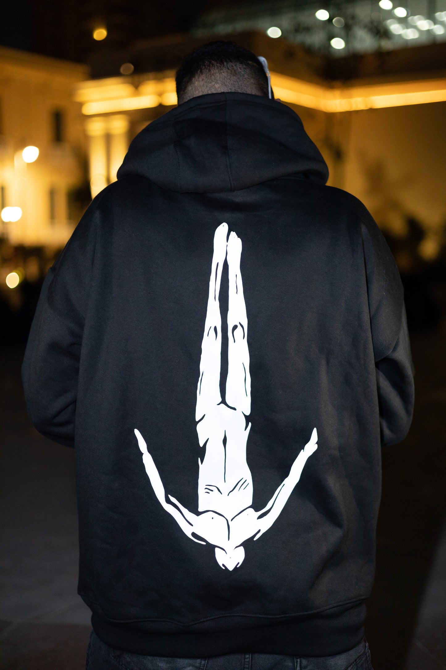 Edgy black oversized hoodie with glowing reflective "After Life" text and logo graphic when hit by light - made for making a scene at night festivals.